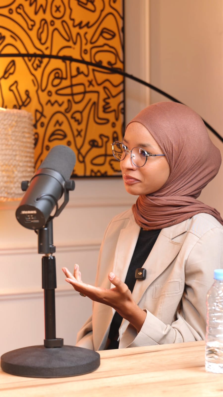 Imane speaking into a studio microphone
